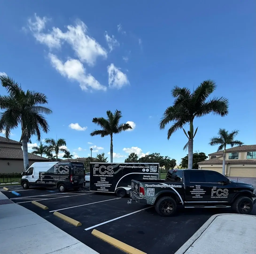 Three black service vehicles branded with the Floor Coating Specialist logo and contact information parked in a sunny lot with palm trees. - Floor Coating Specialist - Bradenton, FL